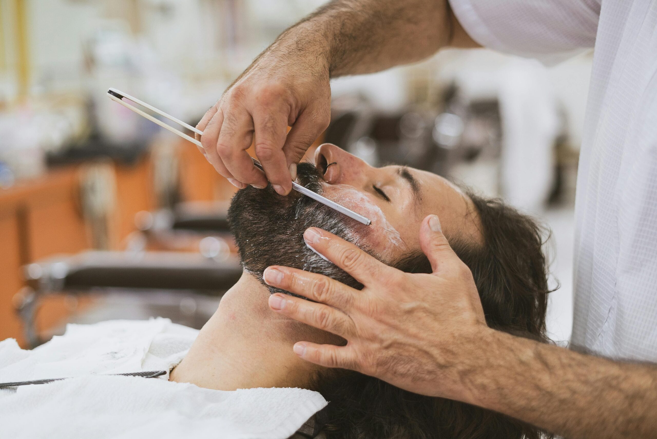 Barbero afeitando con navaja