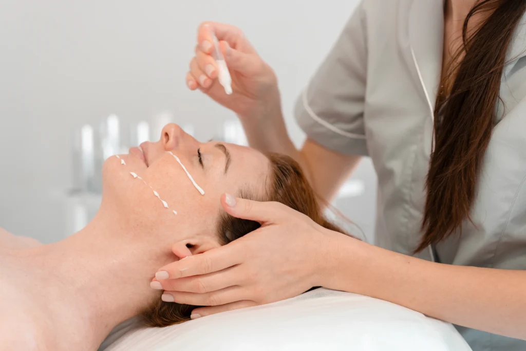 Esteticista aplicando sérum a clienta